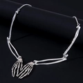 Detailed view of silver skull hand skeletal pendant on black cylindrical stand - One Size / Skeleton Claw Style (HAUJ221182) / Silver