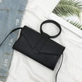 Minimalist black envelope crossbody bag with circular handle and slender strap - Black