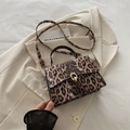 Umhängetasche mit Leopardenmuster und goldenem Metallschloss auf cremefarbenem Blazer - Braun