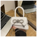 Detail of white mini handbag with silver rhinestone bow and sleek metallic chain strap - White