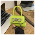 Mini green crossbody bag with rhinestone bow and silver chain strap in hand - Green