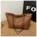 Detail shot of brown quilted PU leather tote bag with metal chain strap and logo - Brown