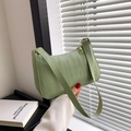 Sac à épaule baguette vert clair avec motif crocodile tenu à la main de façon élégante - PU Vert