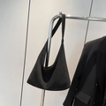 Minimalist black large capacity hobo shoulder bag hanging on a rack for daily commute - Black