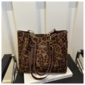 Détail du sac cabas léopard avec anses en cuir marron et chaîne décorative dorée élégante - Marron