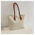 Detalle del bolso tote crema con asas marrones y costuras verticales sobre fondo blanco - Blanco
