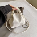 Detail of white matte bucket bag with marble bead handle and silver chain strap - Off White