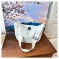 Close-up of a white waterproof nylon crescent crossbody bag with black zippers on wood - White