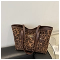 Dettaglio della borsa shopper leopardata con manici in pelle e rivetti metallici - Marrone