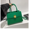 Détail d'un sac à main vert en cuir avec texture crocodile et fermoir en métal doré géométrique - Vert