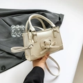 Creamy white textured PU leather square bag with bow and heart detail in hand - Pearl White