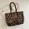 Faux fur leopard print tote bag with brown leather straps on beige blazer background - Brown