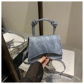 Detail der blauen Denim-Minitasche mit einzigartigem Knotengriff und goldenen Metallteilen - Himmelblau