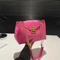 Magenta crossbody bag with smooth leather finish and gold chain strap in hand - Rose Red