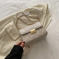 Sac à bandoulière matelassé beige élégant avec chaîne dorée sur fond minimaliste chic - Beige