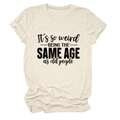 Dettaglio delle maniche rimboccate e testo stampato su t-shirt beige girocollo - S / Sabbia (Carattere Nero)