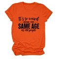 Détail d'un t-shirt orange vif à col rond avec slogan noir et revers aux manches - Orange (Police Noire)