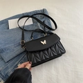 Black macaron crossbody bag featuring quilted lattice pattern and white butterfly detail - Black