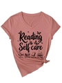 Detail of mauve pink cotton T-shirt featuring Reading is Self Care text and book graphics - Rose Gold (Black Graphic)