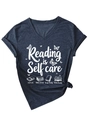 Detail of V-neck T-shirt showing Reading is Self Care print and knotted hem design - Navy Blue (White Graphic)