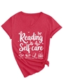 Detail of red V-neck T-shirt with 'Reading is Self Care' print and knotted hem design - Red (White Graphic)