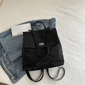 Sac à dos noir à texture froissée avec fermoir tournant en métal argenté sur denim - Noir