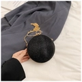 Detailansicht einer schwarzen Kugel-Abendtasche mit Glitzereffekt und goldenem Ringgriff - Schwarz