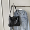 Minimalist black leather tote bag with decorative bow and zipper closure on a metal stand - Black without Pendant