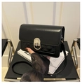 Detalle de bolso bandolera negro con costuras acolchadas y cierre metálico plateado en U - Negro