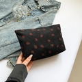 Black corduroy clutch bag with strawberry print and practical black wrist strap - Black