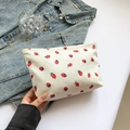 White corduroy storage pouch featuring a vibrant red strawberry print with zip closure - White