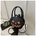 Close-up of black round Halloween pumpkin crossbody bag with orange face and double handles - Black and Orange