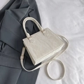 Creamy textured leather tote bag with cylindrical handles and adjustable shoulder strap - White