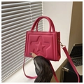 Detail of hot pink crossbody bag with embossed star pattern and top handle strap - Rose Pink