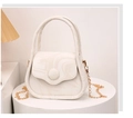Dettaglio mini borsa bianca effetto marmo con tracolla a catena dorata su pedana - Bianco