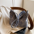 Blau-weiße gewebte Schultertasche mit geometrischen Mustern auf einem Holzstuhl - Blau