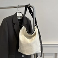 Borsa a secchiello in tela bianca con ampia tracolla nera su un appendiabiti - Bianco