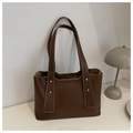 Detail of dark brown leather tote bag with white contrast stitching and gold rivets - Brown