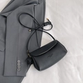 Minimalist black pebble leather crossbody bag with decorative floral charm and gold lettering - Black
