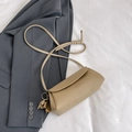 Khaki pebbled leather crossbody bag with tassel and flap closure on gray blazer - Khaki