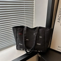 Minimalist black canvas tote bag featuring weekly letter print and dual top handles - Black