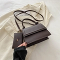 Bolso bandolera de cuero marrón oscuro con mini estuche sobre fondo de chaqueta elegante - Marrón