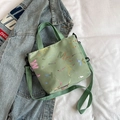 Détail d'un sac bandoulière vert clair avec imprimé graffiti et sangle ajustable - Vert