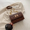 Dark brown quilted crossbody bag with golden bow clasp and chain shoulder strap - Brown