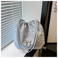 Primer plano de bolso tote plisado azul claro con colgante de mariposa de metal plateado - Azul