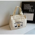 Detail von süßen Bären-Prints und Vordertasche an der cremefarbenen Canvas-Lunchtasche - Gebrochenes Weiß