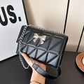 Fashionable black quilted shoulder bag with silver bow hardware and chain strap - Black