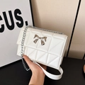 Chic white quilted chain bag featuring a silver metal bow accent and envelope flap - White