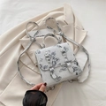 Mini zaino bianco con stampe di farfalle e fibbie argentate su un blazer beige - Argento