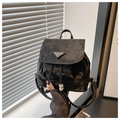 Detalle de una mini mochila negra con logo triangular, cordón y cuentas de madera - Negro